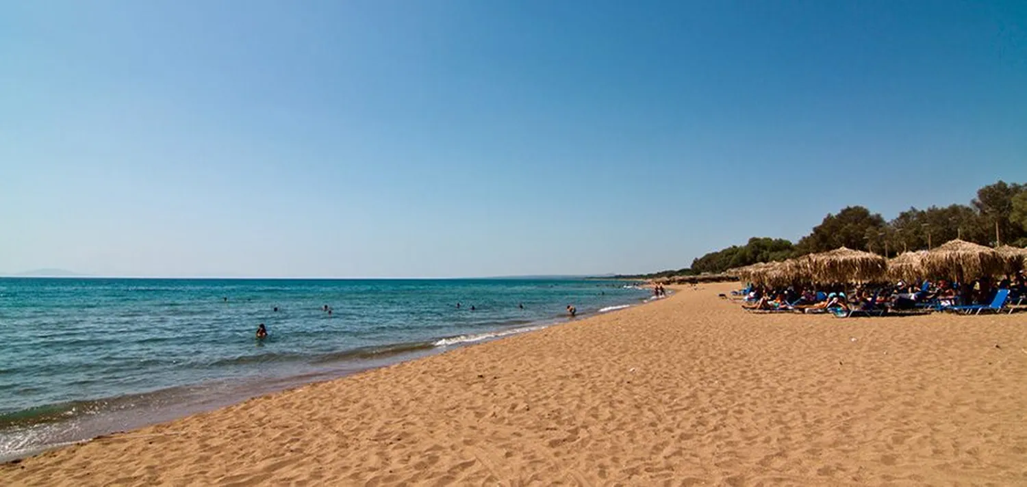 Η αμμουδιά της Κουρούτας με τις ομπρέλες και το γαλάζιο νερό